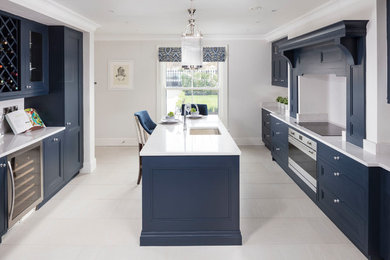 Photo of a transitional u-shaped kitchen in Dublin with shaker cabinets, blue cabinets, quartzite benchtops, mirror splashback, stainless steel appliances, with island, an undermount sink and white splashback.