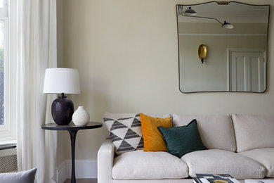 This is an example of a large scandi formal enclosed living room in London with beige walls, medium hardwood flooring, a freestanding tv and brown floors.