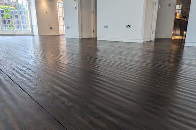 This is an example of a large traditional living room in London with dark hardwood flooring.