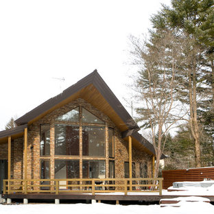 他の地域のコンテンポラリースタイルのおしゃれな家の外観 (レンガサイディング、茶色い外壁、切妻屋根) の写真