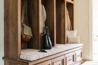 Mudroom - mid-sized rustic medium tone wood floor and brown floor mudroom idea in San Francisco with beige walls