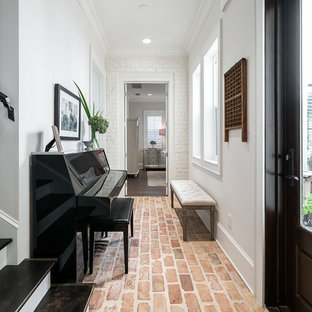 Foto på en vintage hall, med vita väggar, tegelgolv och rött golv