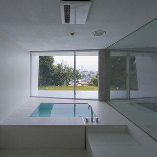 Ispirazione per una stanza da bagno minimalista con vasca idromassaggio, piastrelle bianche e pareti bianche