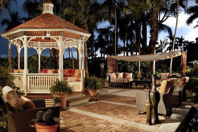 This is an example of a tropical patio in Miami with a gazebo/cabana.