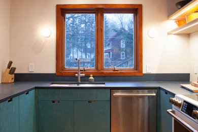 Inspiration for a modern u-shaped dark wood floor kitchen remodel in Boston with an undermount sink, flat-panel cabinets, blue cabinets, concrete countertops, stainless steel appliances and blue countertops