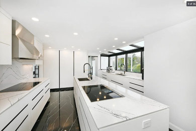 Exempel på ett avskilt, stort modernt vit vitt u-kök, med en undermonterad diskho, släta luckor, vita skåp, marmorbänkskiva, stänkskydd i marmor, svarta vitvaror, marmorgolv, en köksö och svart golv