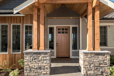 Entryway - large craftsman concrete floor entryway idea in Seattle with beige walls and a light wood front door