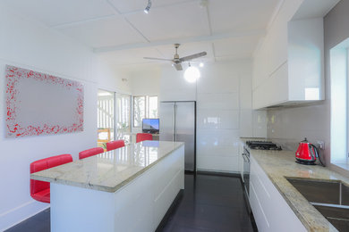 Photo of a modern separate kitchen in Brisbane with an undermount sink, white cabinets, painted wood floors and with island.