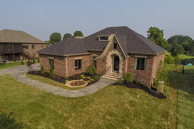 Large elegant red two-story brick exterior home photo in Louisville