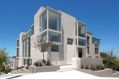 Huge trendy beige three-story stone exterior home photo in San Francisco with a mixed material roof and a gray roof