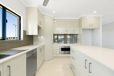 This is an example of a mid-sized modern l-shaped eat-in kitchen in Cairns with a double-bowl sink, beige cabinets, limestone benchtops, brown splashback, ceramic splashback, stainless steel appliances, ceramic floors and with island.