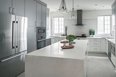 Modern inredning av ett stort vit vitt kök, med en undermonterad diskho, släta luckor, grå skåp, bänkskiva i kvartsit, vitt stänkskydd, stänkskydd i porslinskakel, rostfria vitvaror, klinkergolv i keramik, en köksö och grått golv