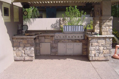 Example of a small classic backyard decomposed granite patio kitchen design in Phoenix with an awning