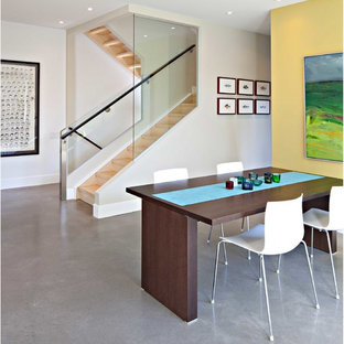 Идея дизайна: гостиная-столовая среднего размера в современном стиле с желтыми стенами, бетонным полом и серым полом без камина