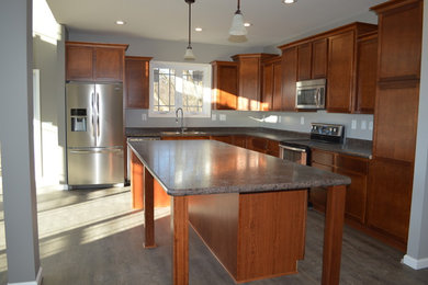 Inspiration for a mid-sized timeless l-shaped vinyl floor eat-in kitchen remodel in Detroit with a double-bowl sink, medium tone wood cabinets, stainless steel appliances and an island