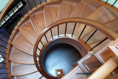 Mid-sized transitional wood spiral staircase in Seattle with wood risers.