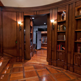 Imagen de despacho clásico, de tamaño medio, sin chimenea, con paredes marrones, suelo de madera en tonos medios y suelo marrón