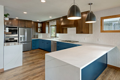 Inspiration for a mid-sized mid-century modern u-shaped vinyl floor and brown floor eat-in kitchen remodel in Minneapolis with an undermount sink, flat-panel cabinets, blue cabinets, quartzite countertops, white backsplash, ceramic backsplash, stainless steel appliances, an island and white countertops
