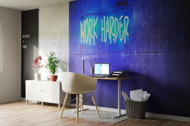 Mittelgroßes Modernes Arbeitszimmer mit Arbeitsplatz, blauer Wandfarbe, braunem Holzboden, freistehendem Schreibtisch und Tapetenwänden in Sonstige