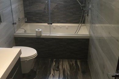 Example of a small trendy kids' porcelain tile porcelain tile bathroom design in New York with a wall-mount toilet and gray walls