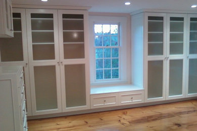 Inspiration for a large modern gender-neutral light wood floor walk-in closet remodel in Boston