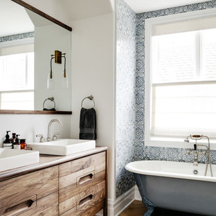 Transitional blue tile and white tile medium tone wood floor and brown floor claw-foot bathtub photo in San Francisco with furniture-like cabinets, dark wood cabinets, white walls, a drop-in sink, wood countertops and brown countertops