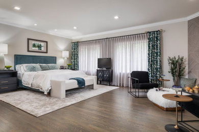 Mid-sized trendy master medium tone wood floor and brown floor bedroom photo in Los Angeles with beige walls, a corner fireplace and a tile fireplace