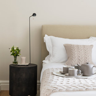 ロンドンのコンテンポラリースタイルのおしゃれな寝室 (ベージュの壁、無垢フローリング、暖炉なし) のインテリア