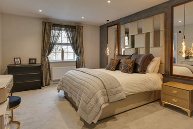 This is an example of a medium sized contemporary master bedroom in Essex with grey walls, carpet, grey floors and a feature wall.