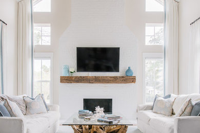 Inspiration for a large coastal open concept carpeted and blue floor living room remodel in Jacksonville with a standard fireplace, a brick fireplace, gray walls and a wall-mounted tv
