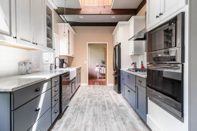 Large minimalist galley vinyl floor, gray floor and exposed beam kitchen photo in Cleveland with a farmhouse sink, quartzite countertops, white backsplash, ceramic backsplash, stainless steel appliances and white countertops