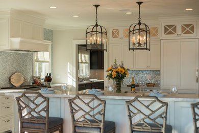 Large elegant u-shaped medium tone wood floor enclosed kitchen photo in Milwaukee with a farmhouse sink, flat-panel cabinets, white cabinets, blue backsplash, mosaic tile backsplash, stainless steel appliances and an island