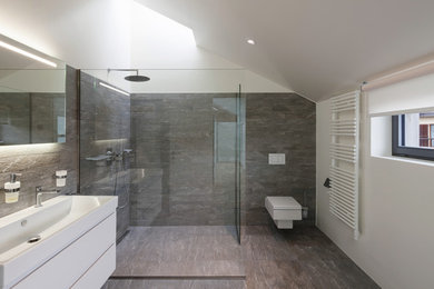 This is an example of a contemporary 3/4 wet room bathroom in London with a wall-mount toilet, a trough sink and an open shower.