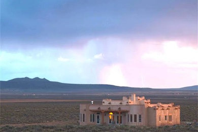 Mid-sized southwestern beige one-story adobe flat roof idea in Albuquerque
