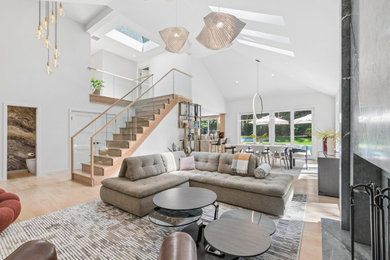 Trendy loft-style beige floor and vaulted ceiling living room photo in New York with white walls, a standard fireplace and a stone fireplace