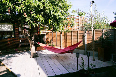 Design ideas for a small bohemian back partial sun garden for summer in Cambridgeshire with a potted garden and decking.