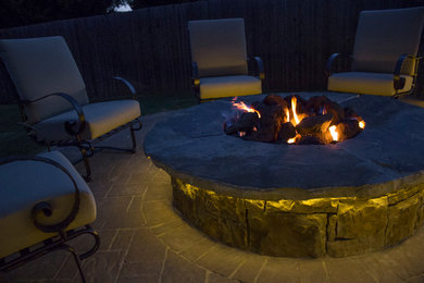 Photo of a mid-sized arts and crafts backyard patio in Oklahoma City with a fire feature and brick pavers.