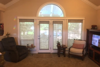 Example of a large classic enclosed carpeted living room design in San Diego with beige walls, no fireplace and a media wall