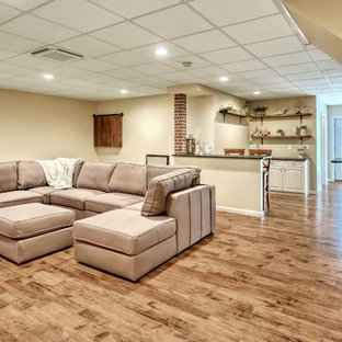 This is an example of a large urban basement in Other with beige walls and laminate floors.