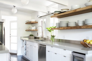 Kitchen - contemporary galley dark wood floor and black floor kitchen idea in San Francisco with an undermount sink, flat-panel cabinets, white cabinets, stainless steel appliances, gray countertops and an island