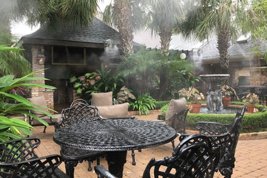 Island style backyard patio photo in New Orleans