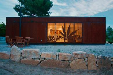 Mid-sized contemporary one-storey brown exterior in Madrid with a flat roof.