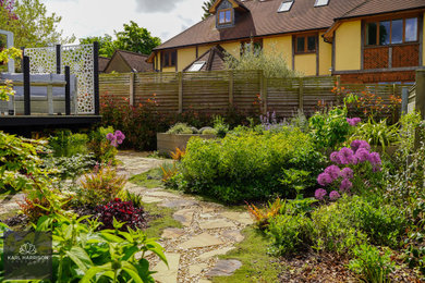 Imagen de jardín escandinavo de tamaño medio en verano en patio trasero con jardín francés, parterre de flores, exposición total al sol, entablado y con madera