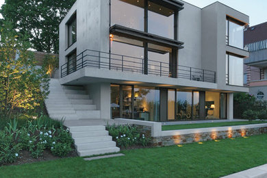 This is an example of a mid-sized modern three-storey concrete grey exterior in Stuttgart with a flat roof.