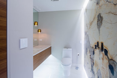 Mid-sized trendy marble floor and white floor bathroom photo in Calgary with a one-piece toilet, multicolored walls, marble countertops and white countertops