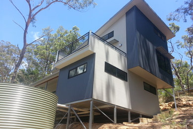 This is an example of a small contemporary two-storey exterior in Sydney with mixed siding and a shed roof.