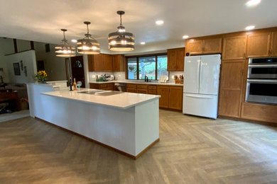 Galley vinyl floor and brown floor kitchen photo in Other with flat-panel cabinets, brown cabinets, quartz countertops, blue backsplash, porcelain backsplash, an island and white countertops