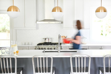 Inspiration for a coastal medium tone wood floor kitchen remodel in Vancouver with white backsplash, ceramic backsplash, an island and white countertops