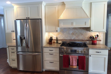 Inspiration for a mid-sized contemporary galley medium tone wood floor open concept kitchen remodel in Philadelphia with a farmhouse sink, shaker cabinets, white cabinets, granite countertops, beige backsplash, ceramic backsplash and stainless steel appliances