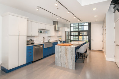 Large trendy single-wall medium tone wood floor eat-in kitchen photo in DC Metro with marble countertops, white backsplash, ceramic backsplash, stainless steel appliances, an island and multicolored countertops